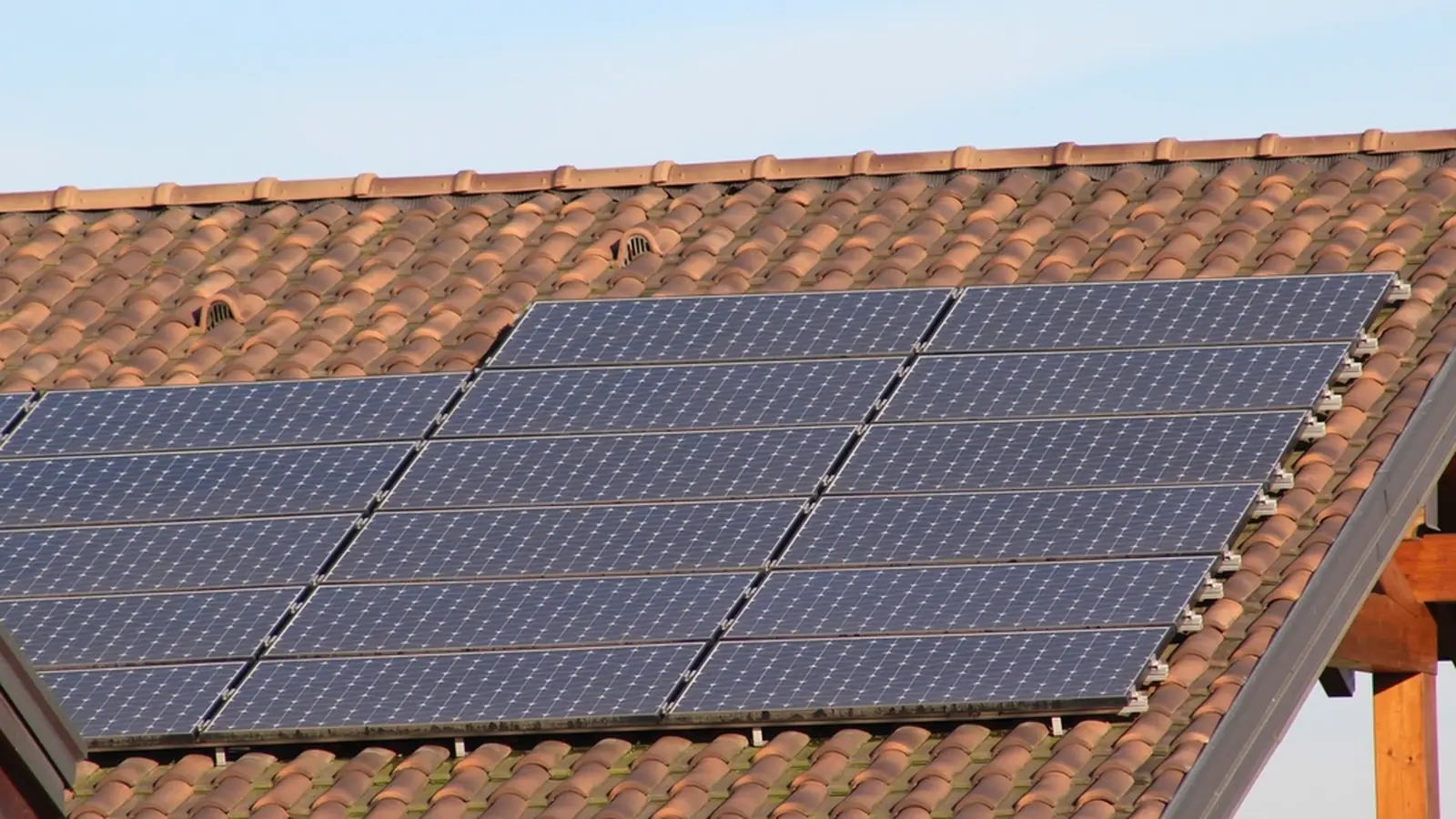 Solar panels mounted in two rows on a terracotta tile roof
